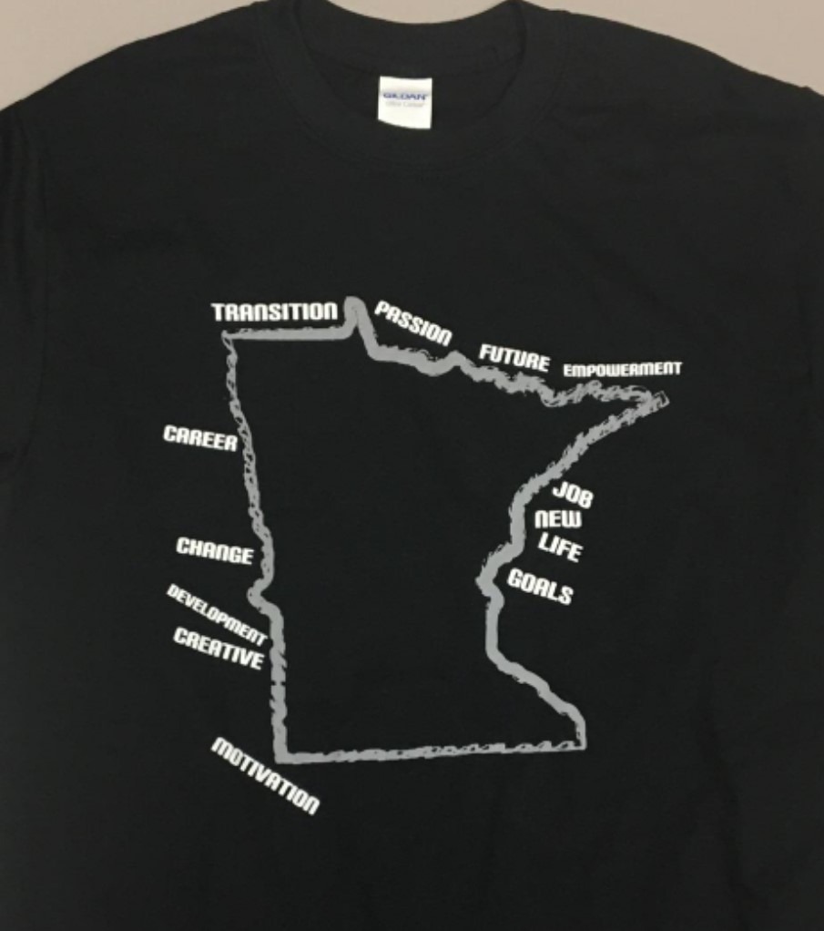 Black t-shirt with a grey outline of Minnesota with the words transition, passion, future, empowerment, job, new life, goals, motivation, creative, development, change, and career in white along the outline.