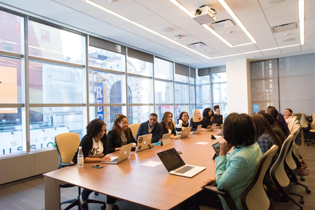 Large group of professionals sitting around a table meeting.